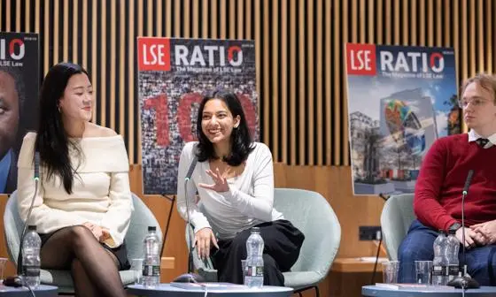 three people sitting in panel discussion, smiling