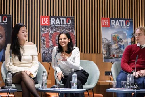 three people sitting in panel discussion, smiling