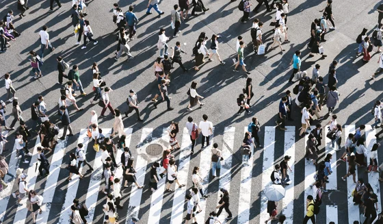 People walking at a busy street crossing.