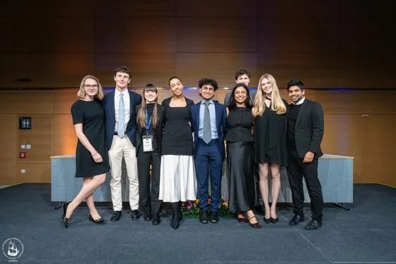9 students in formalwear smiling at the camera