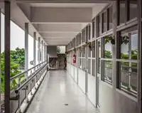 A long school hallway with classrooms on one side and balcony on the other