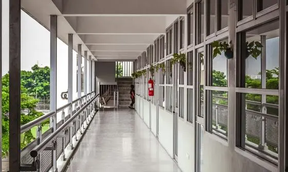 A long school hallway with classrooms on one side and balcony on the other