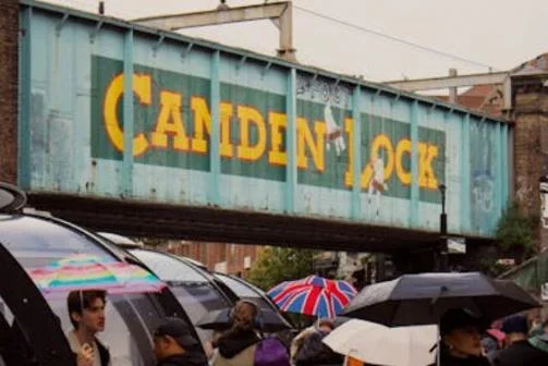People with umbrellas at Camden Lock in London