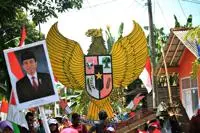 People gathered in the street, holding national symbols and images of former President Joko Widodo