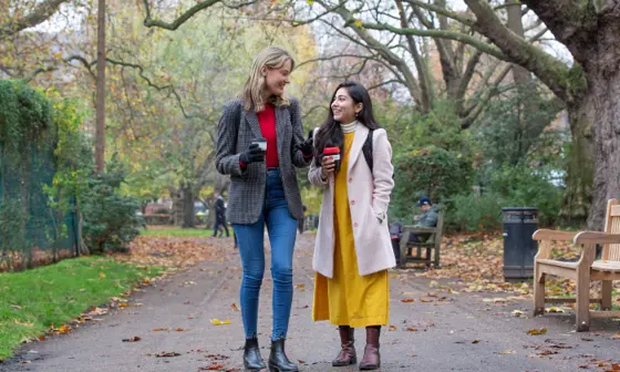 Two girls walking with coffee