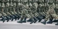 Soldiers dressed in army camouflage march in formation.