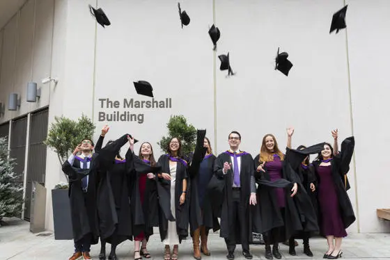 LSE graduates celebrate by throwing their caps in the air
