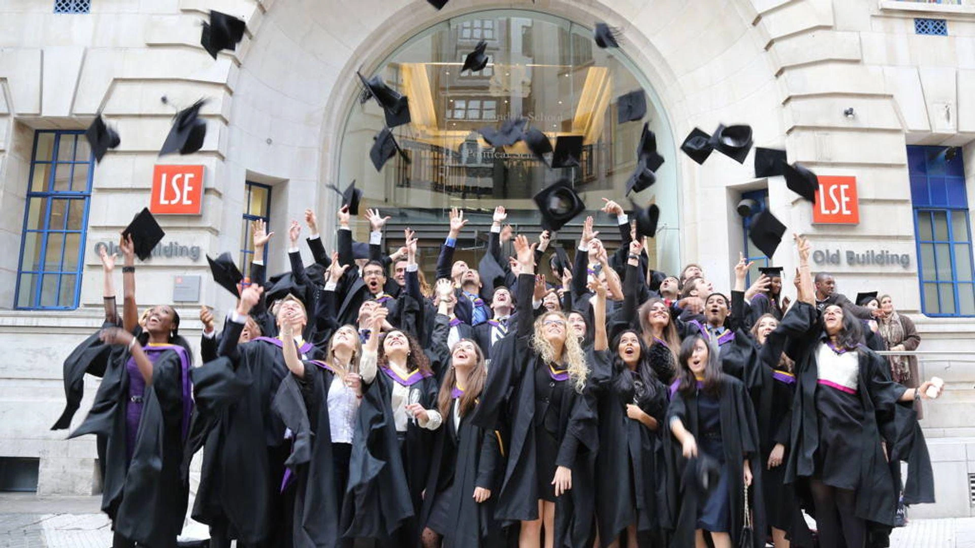 LSE graduates throwing their caps outside the Old Building at graduation