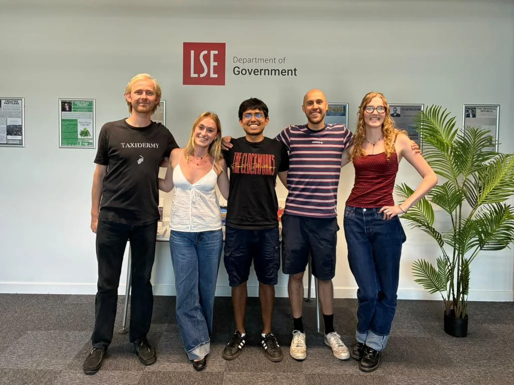 Five people stood arm in arm smiling