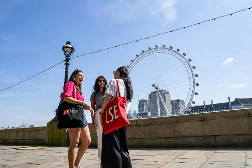 Students by the Thames river overlooking the London Eye, in June 2024