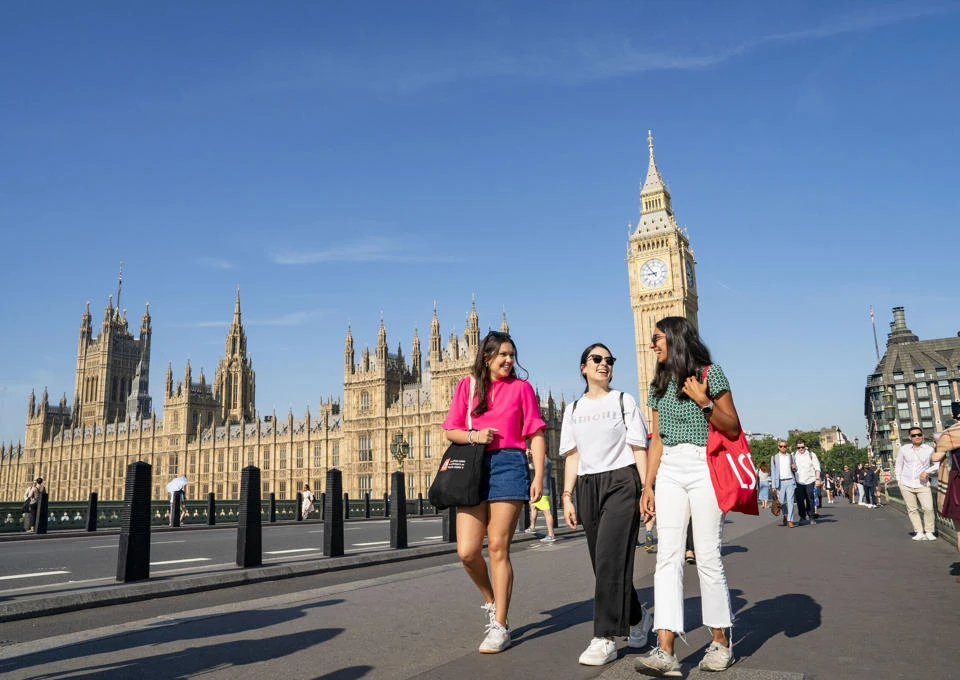 LSE students walking around Westminster in London with the Houses of Parliament in the background