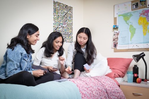 A group of students sat on a bed
