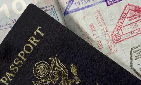 A passport front cover on top of an open passport