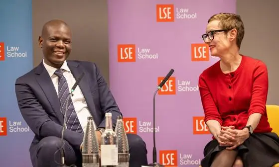 A man and woman sitting behind a microphone smiling