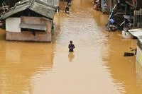 A person waist-deep in flood water.