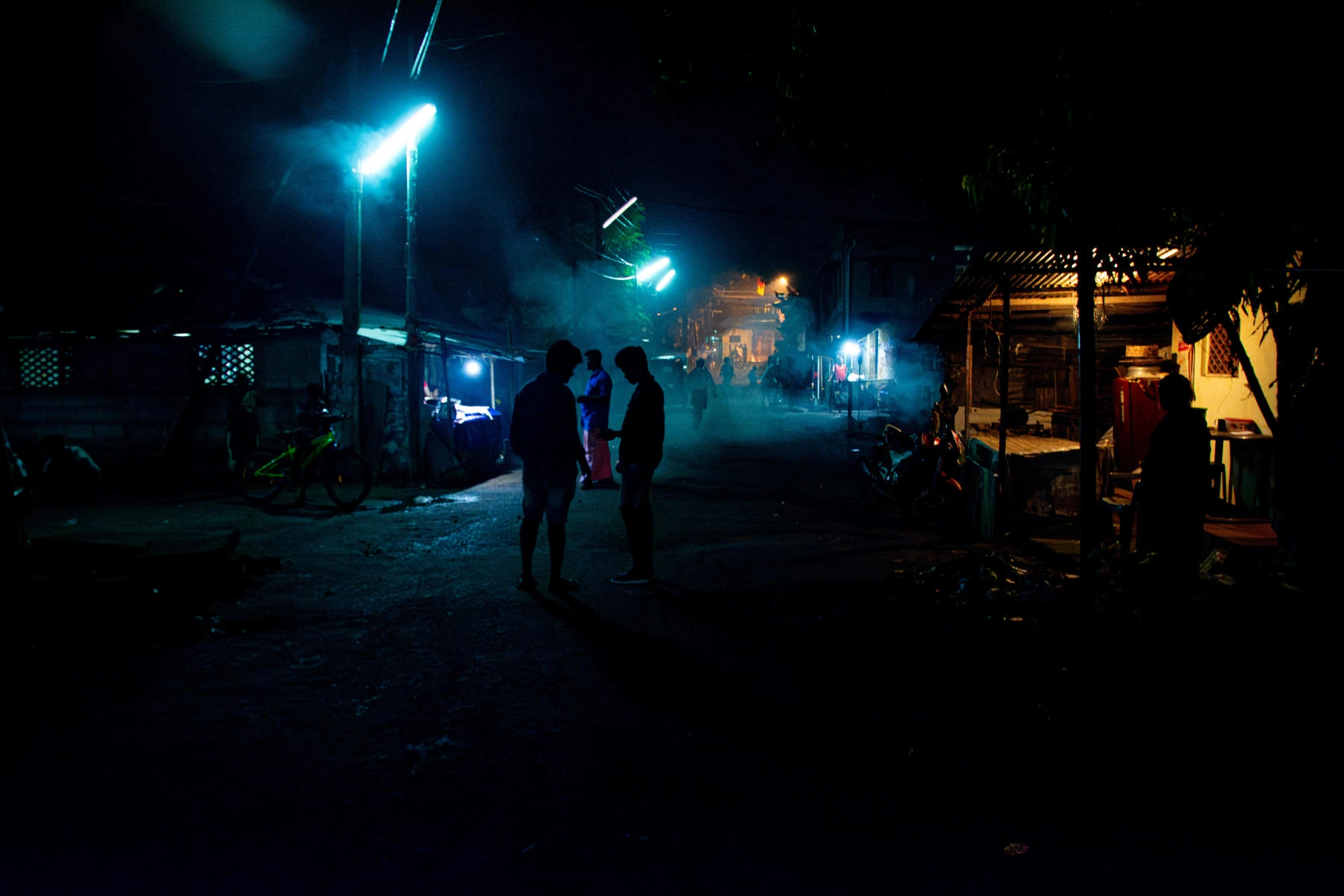 A dark street with lighting.