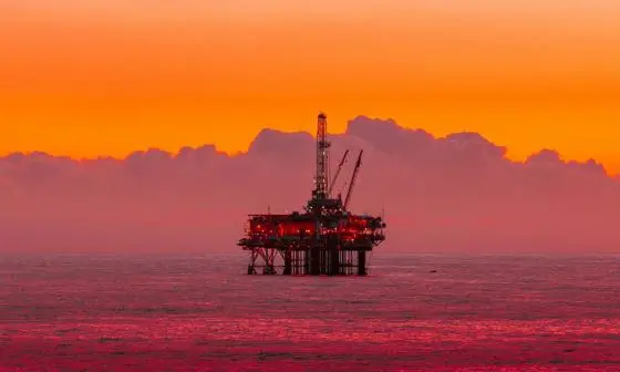 Oil rig in the sea during sun set.