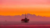 Oil rig in the sea during sun set.