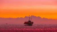 Oil rig in the sea during sun set.