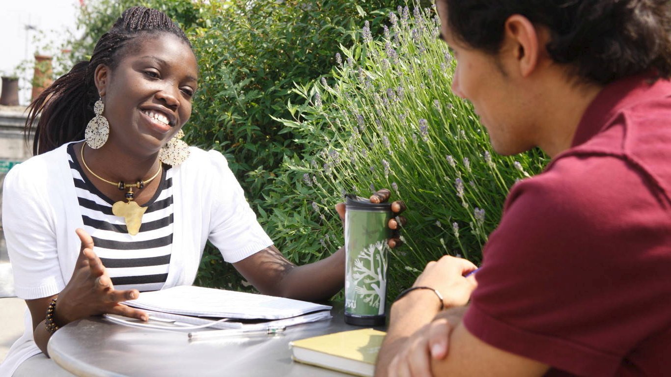 Students talking at a table by garden