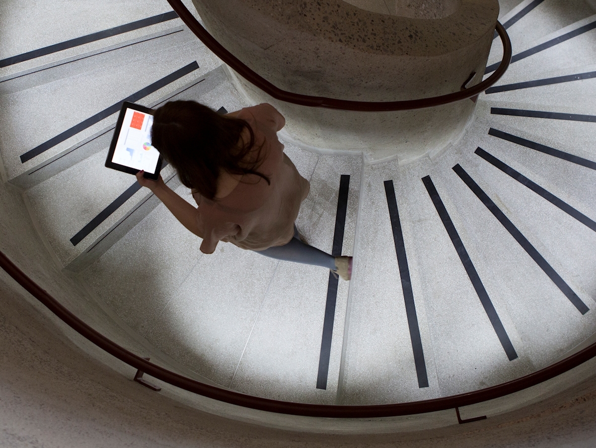 Student walking up stairs with laptop