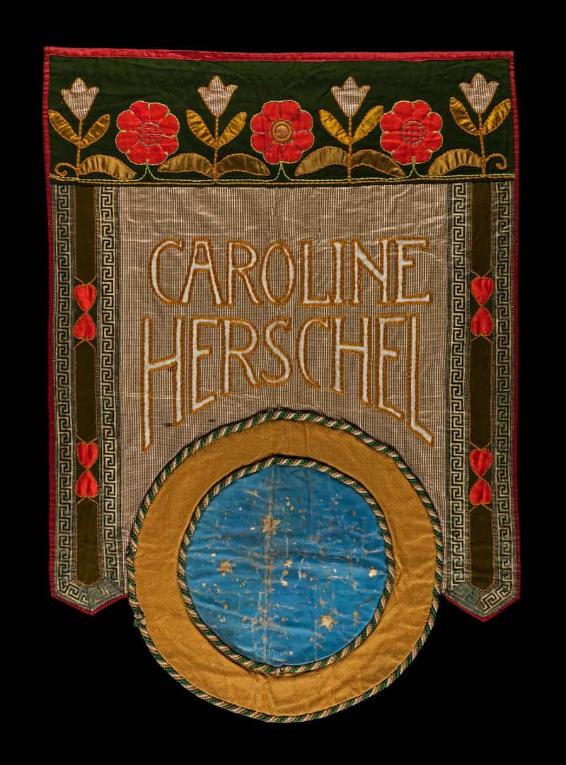 An embroidered banner with Caroline Herschel written on it