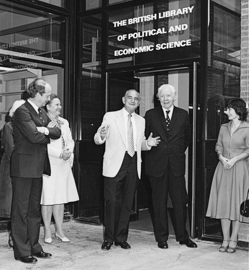 A group of people, including Lionel Robbins, stood at the entrance to the British Library of Political and Economic Science at the occasion of its opening.