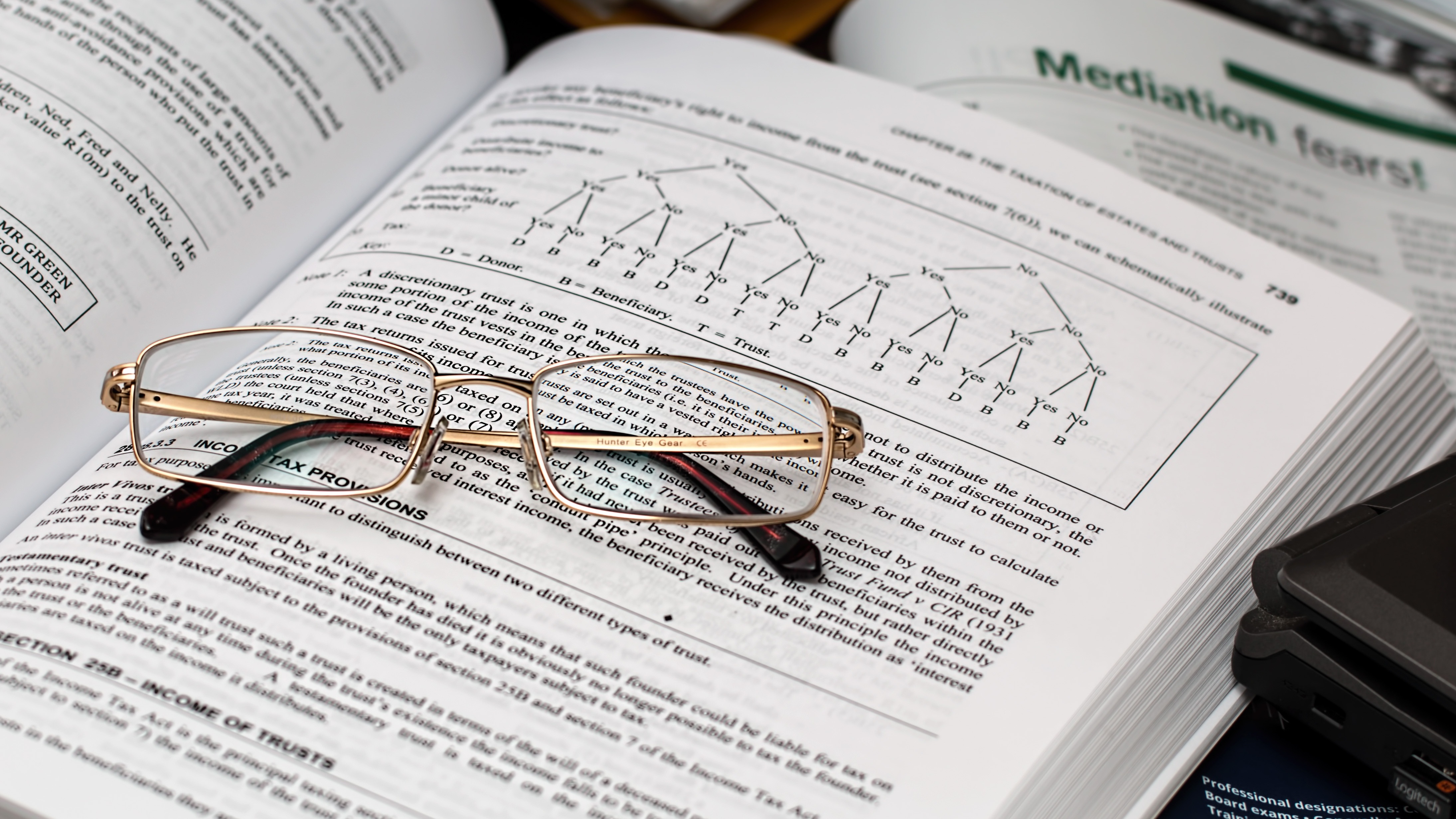 A pair of glasses on an open text book