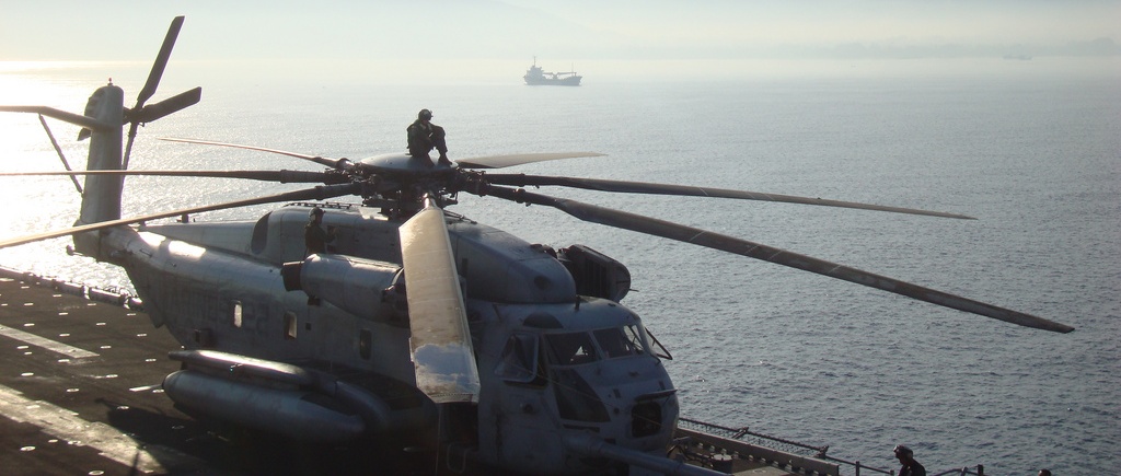 A military helicopter landed on a ship at sea