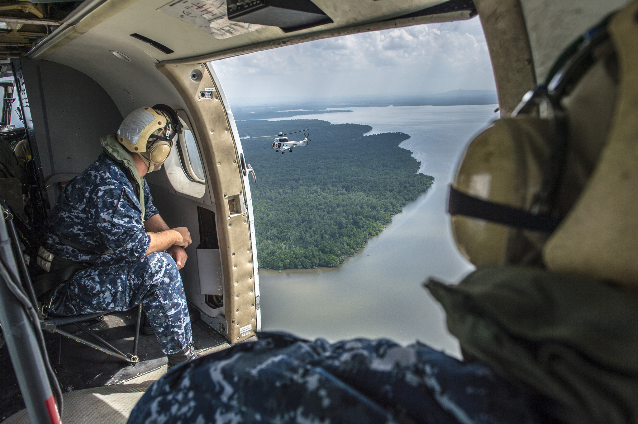 Two US miliary in a helicopter looking out onto East Timor