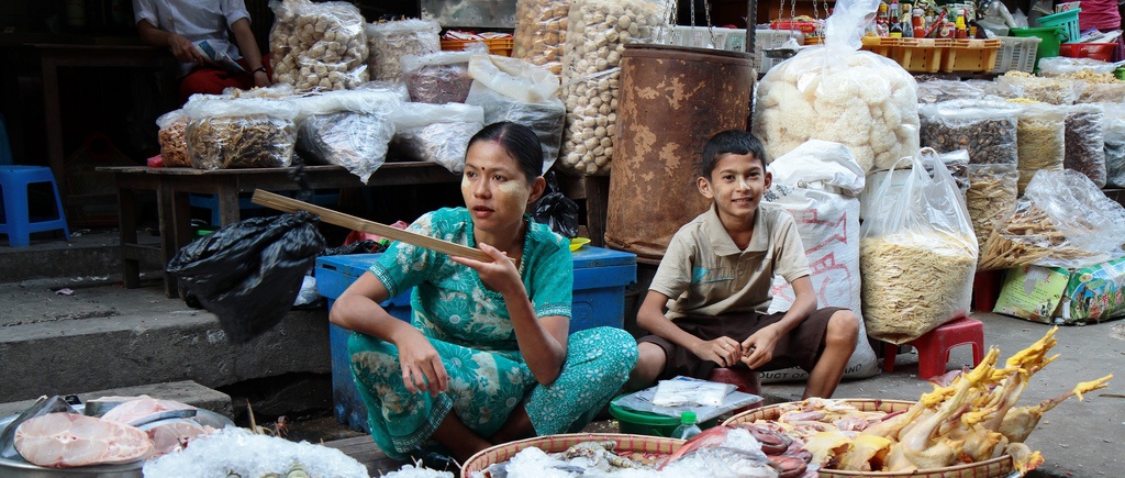 A mother and son selling goods at a street market in Yangon