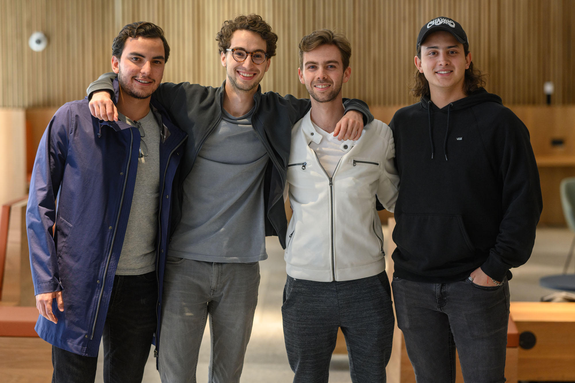 Four smiling male students with arms around each other