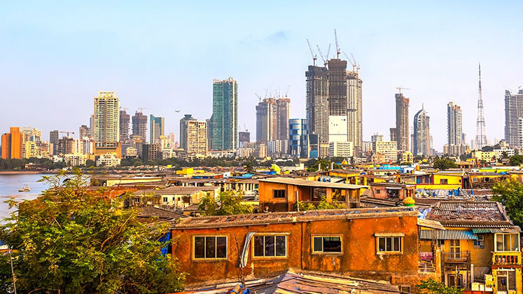 Slums in the foreground are overshadowed by skyscrapers in the distance