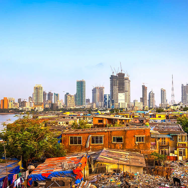 A slum suburb is overshadowed by the skyscrapers beyond