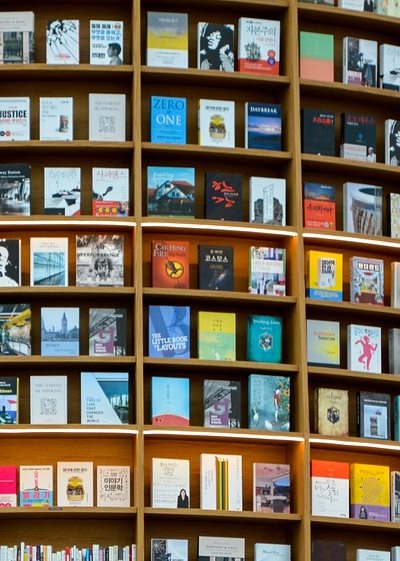 Chinese woman on escalator in bookshop with shelves in background