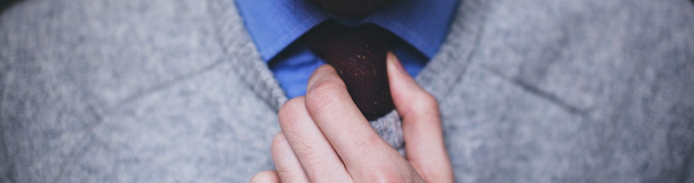 Smartly dressed man fixing tie