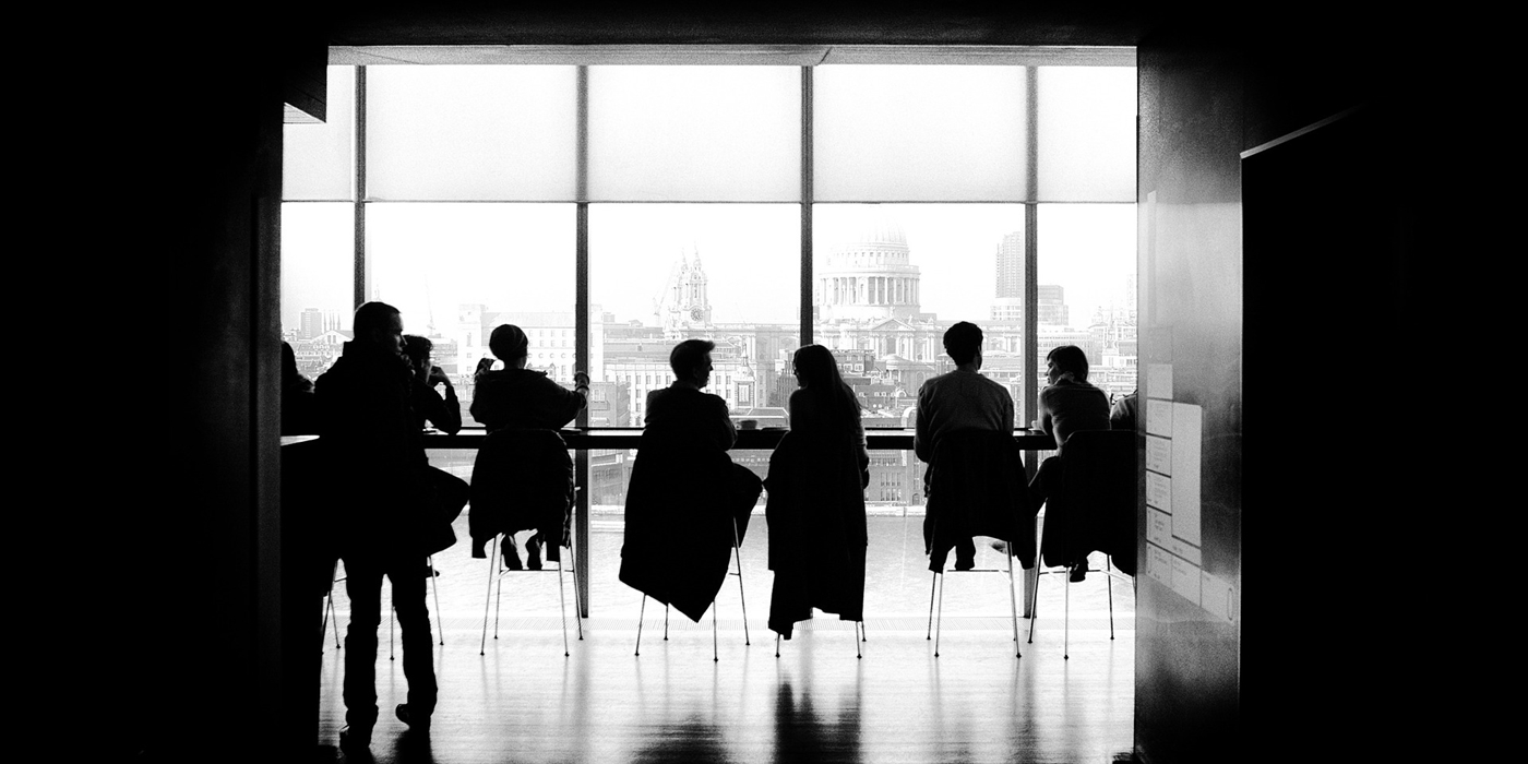 People sitting in a smart looking room overlooking a city