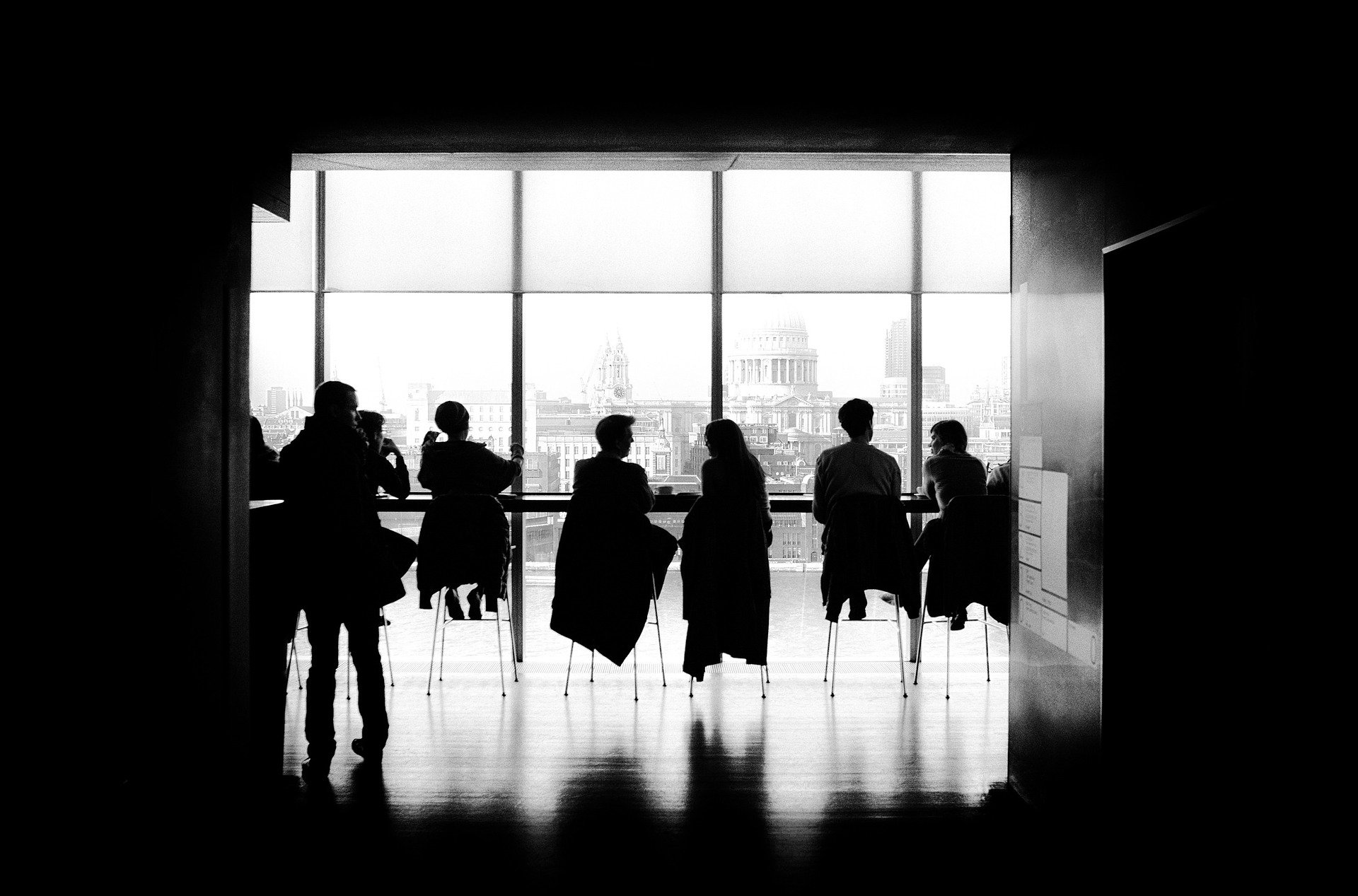 People sitting in a smart looking room overlooking a city