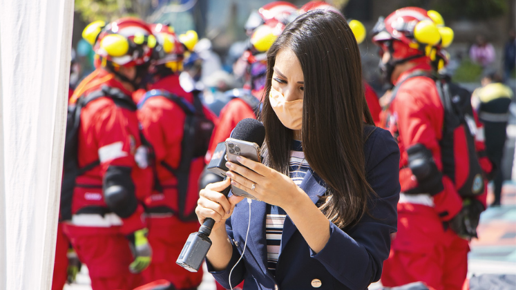 Female reporter holding phone and microphone and wearing a mask_747x420 via Pixabay