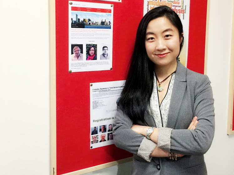 Researcher Yajing Zhu standing beside a notice board | LSE researcher