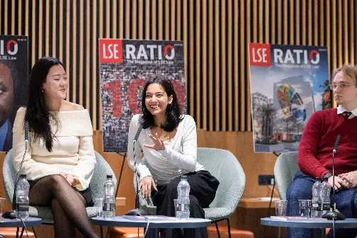 three people sitting in panel discussion, smiling