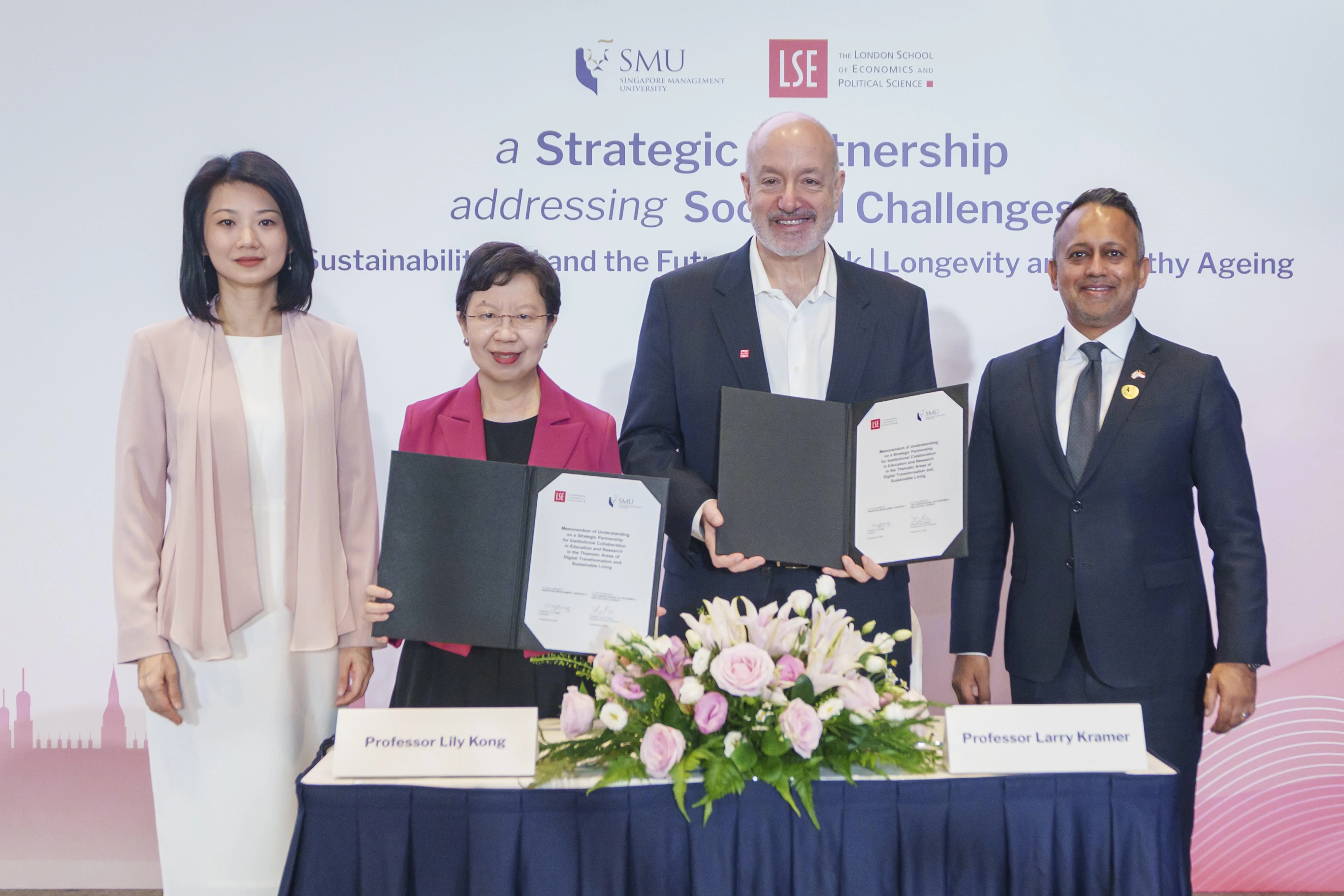 Four individuals posed during the LSE-SMU seed fund singing ceremony. The two Presidents are holding the signed Memorandum of Understanding.