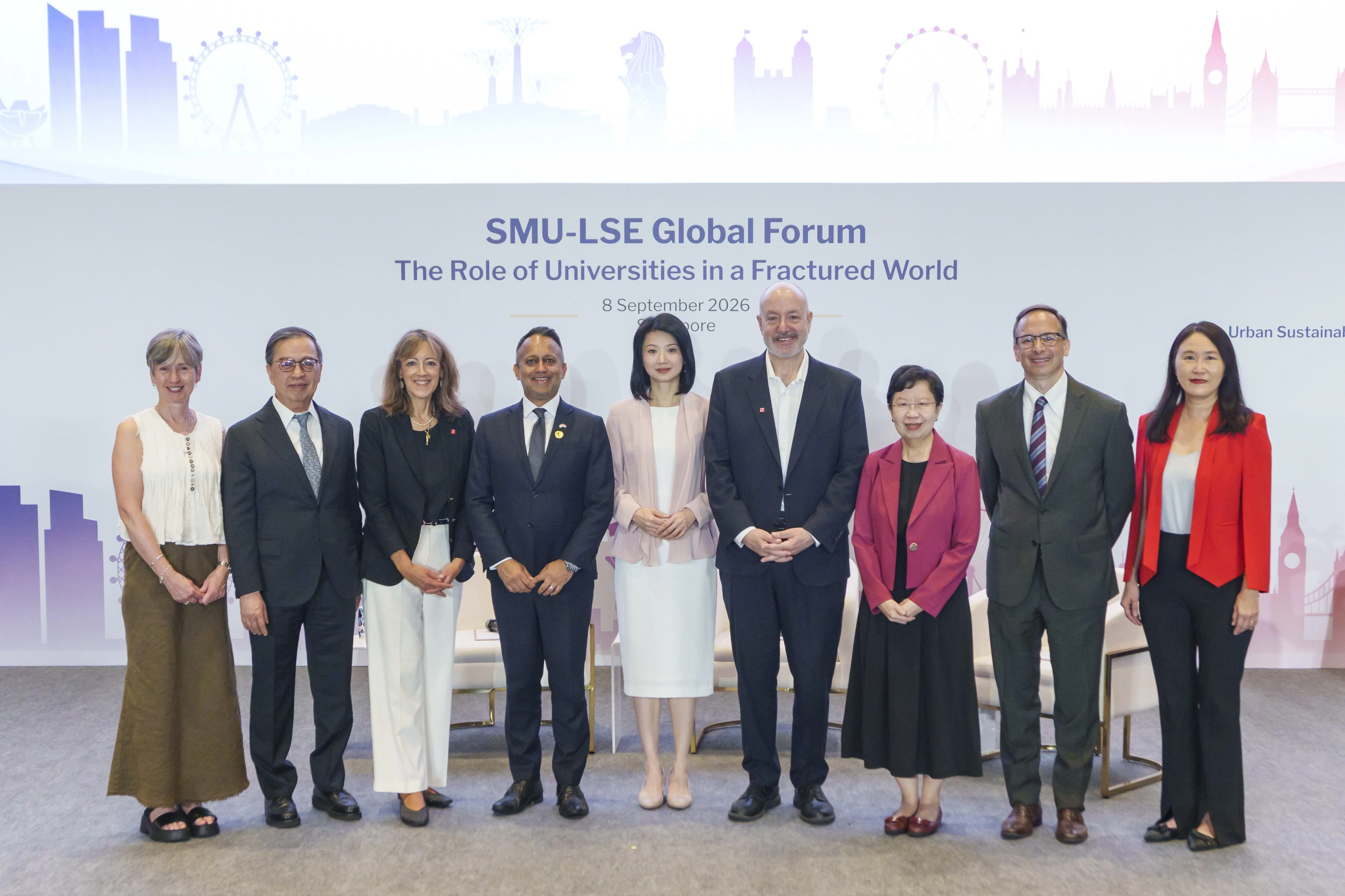 A group of nine individuals posing for a photo on a stage at the SMU-LSE Global Forum.