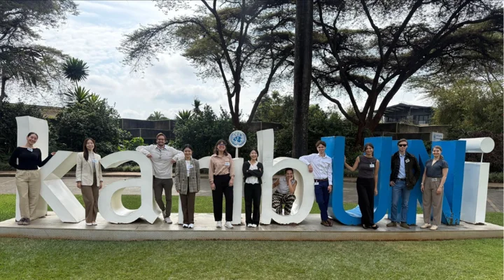 A photo of 11 students posing in front of large letters outside of the UN Conference Centre.