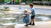 two children playing in a fountain installation
