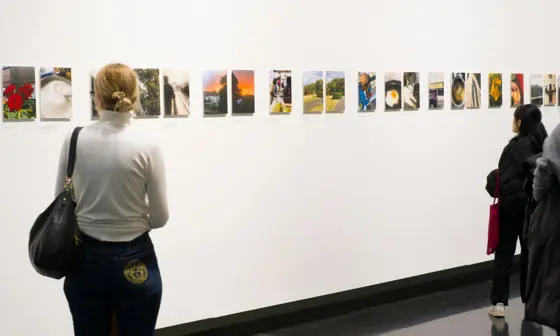 People looking at exhibition of photographs about life during a cost of living crisis