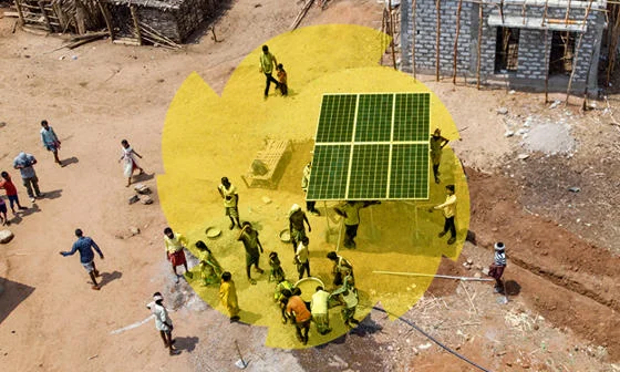 A solar panel being carried through a village