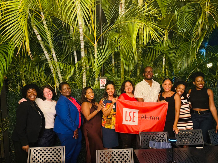 Alumni in Kingston, Jamaica, pose with an LSE alumni banner during Global Networking Night 2025