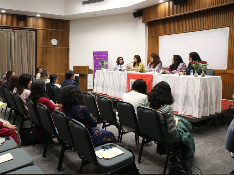 A panel of alumni talk during an event in India