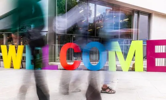 Welcome sculpture with passersby
